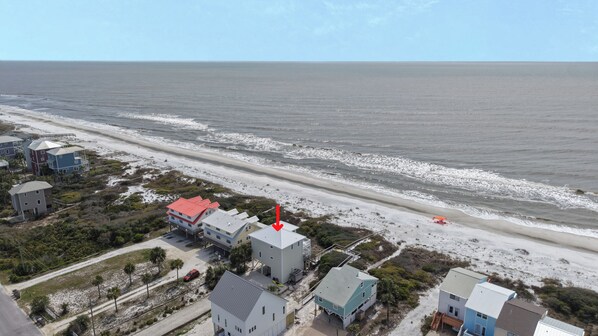 A coastal property with multiple buildings, a beach, and a view of the ocean.