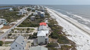 A coastal residential area with houses, a beach, and a road.