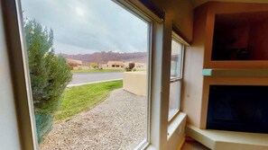 A room with a large window offering a view of a parking lot and distant buildings. - La Sal Overlook - S3, Best Views in Rim Village (Moab)