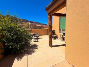 An outdoor patio with a table and chairs, a grill, and a view of a mountain range. - La Sal Overlook - S3, Best Views in Rim Village (Moab)