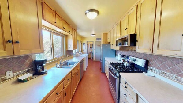 A kitchen with wooden cabinets, a stove, and a coffee maker.