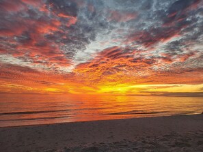 A beach with a sunset and clouds.