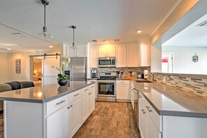 A modern kitchen with white cabinets, stainless steel appliances, and a large island. - Swim, Putt & Explore! Classic Desert Phoenix Ranch (Phoenix)