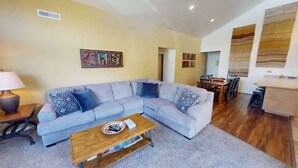 Un salon comprenant un canapé, une table basse et un coin repas avec des chaises et une table.