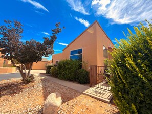 A single-story building with a flat roof, a gated entrance, and a paved driveway. - Desert Hideaway - C2, Enjoy The Views (Moab)