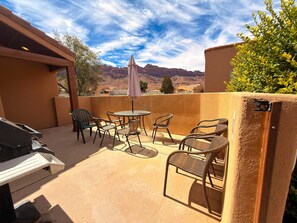 A patio with outdoor furniture, a table, and a grill. - Desert Hideaway - C2, Enjoy The Views (Moab)