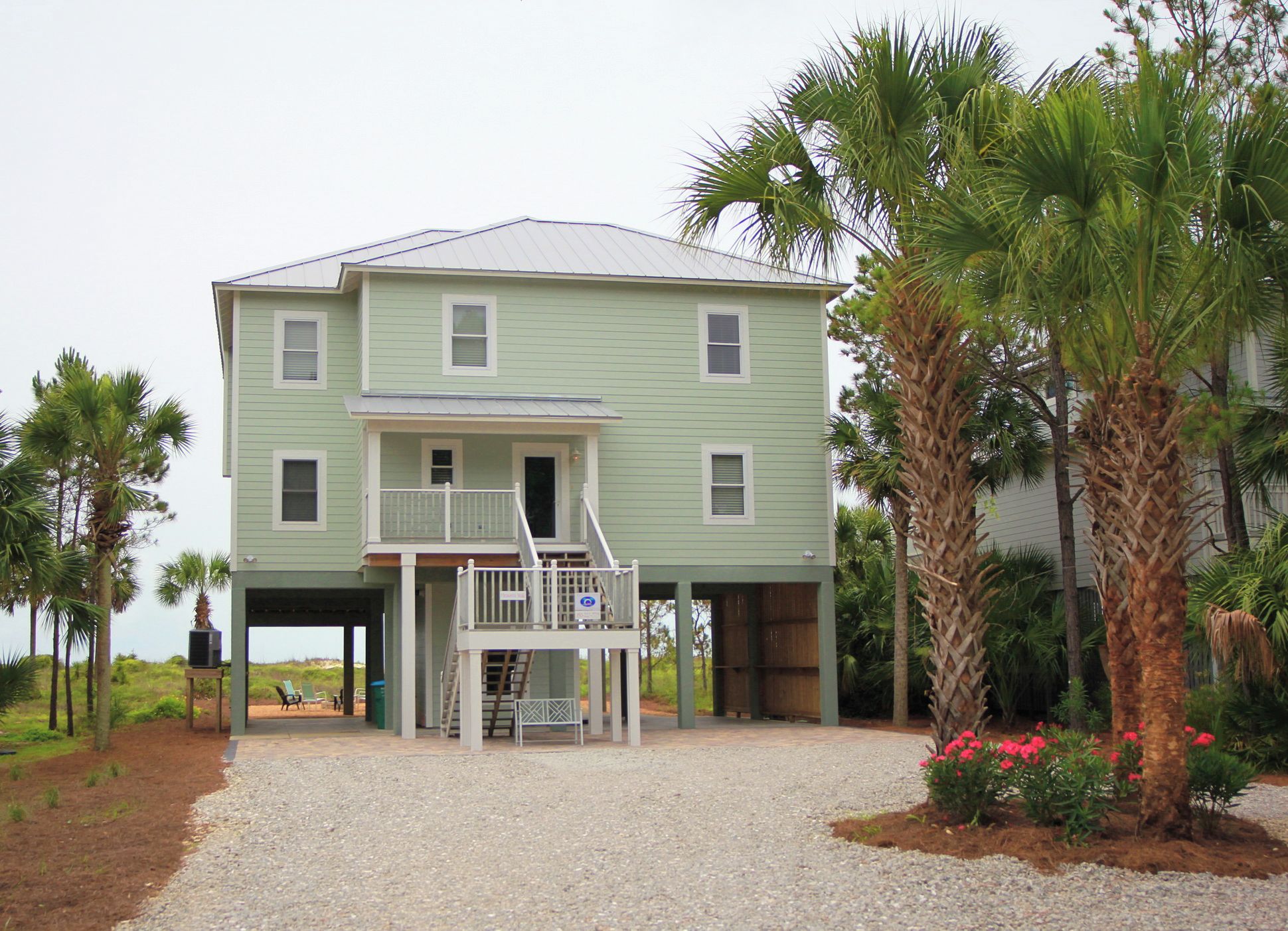 A two-story building with a covered porch and a staircase leading to the upper floor.