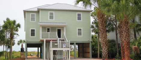 A two-story building with a covered porch and a staircase leading to the upper floor.
