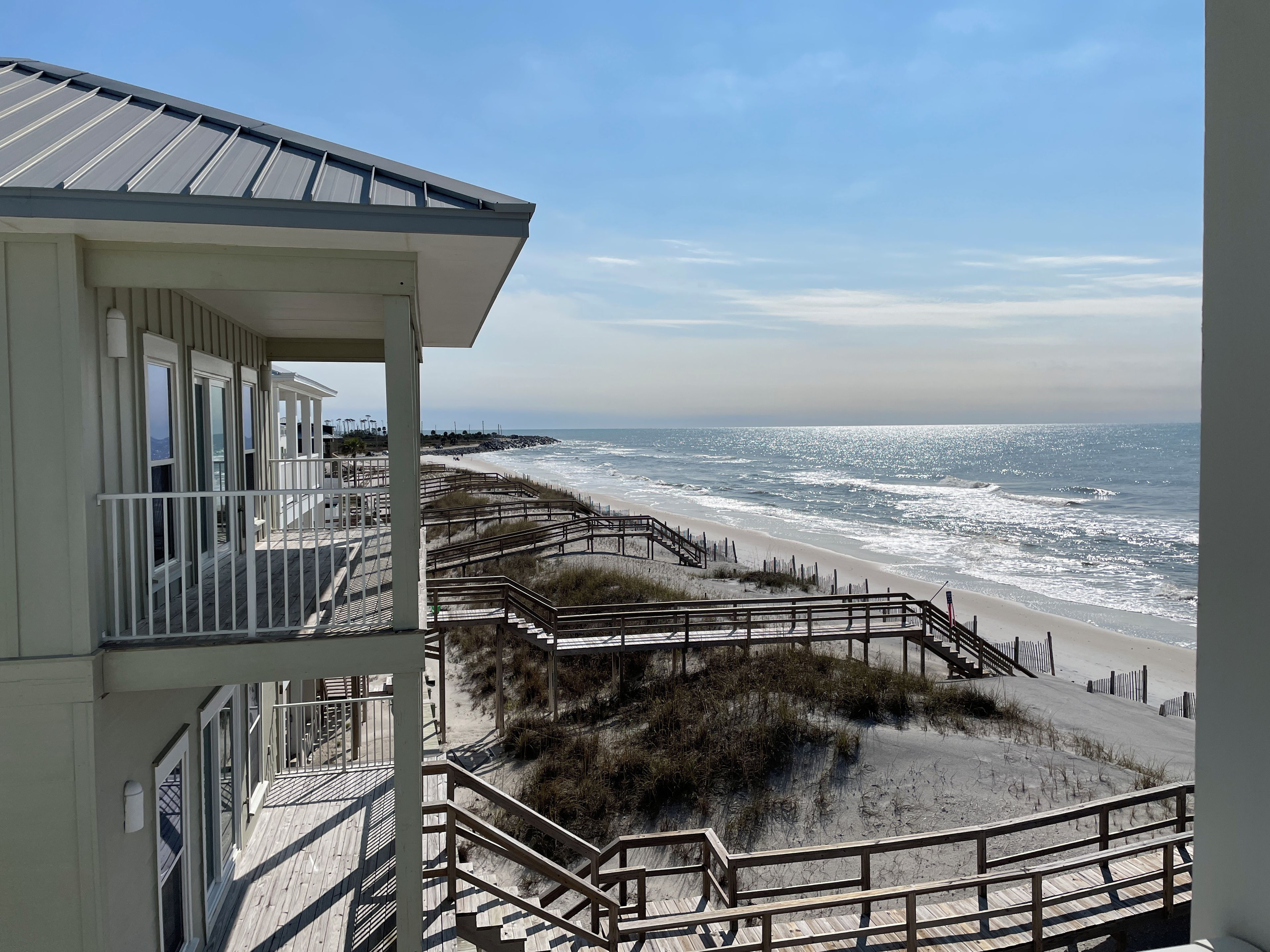A beachfront hotel with a balcony overlooking the ocean.