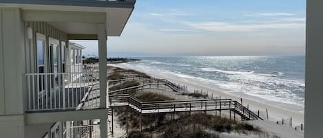 A beachfront hotel with a balcony overlooking the ocean.