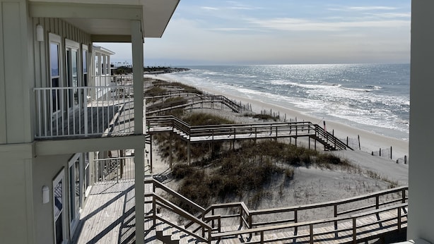 Ein Hotel am Strand mit Balkon und Meerblick.