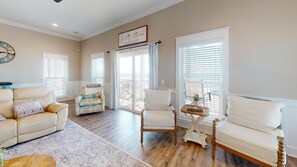 Relax in this inviting living room with a sofa, armchair, and coffee table, offering a comfortable space to unwind.