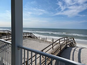 A beach view from a covered walkway with wooden railings and a sandy beach. - Gulf Front! Elevator! Just steps to the ocean! (Cape San Blas)