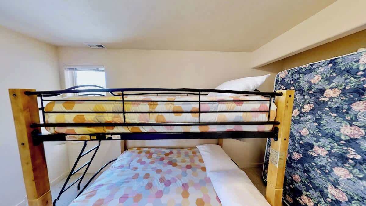 Un letto a castello con una testiera a motivi floreali e una finestra sullo sfondo.