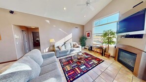 A spacious living room with a sofa, a coffee table, and a fireplace.