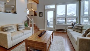 A spacious living room with a wooden coffee table, two beige sofas, and a staircase leading to an upper level. - Private Mountain Town home Pet Friendly - with Great Views! WD12 (Copper Mountain)