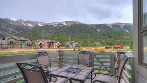 A deck with outdoor seating overlooking a river and a mountainous landscape. - Private Mountain Town home Pet Friendly - with Great Views! WD12 (Copper Mountain)