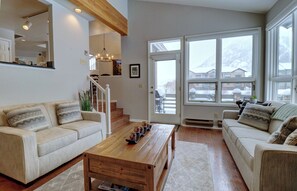 A spacious living room with a wooden coffee table, two beige sofas, and a staircase leading to an upper level. - Private Mountain Town home Pet Friendly - with Great Views! WD12 (Copper Mountain)