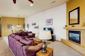 Télévision, cheminée, lecteur de DVD, livres