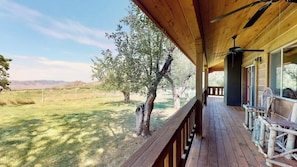 A wooden deck with a view of a grassy field and trees. - Pack Creek - Orchard House, Beautiful Cabin (Moab)