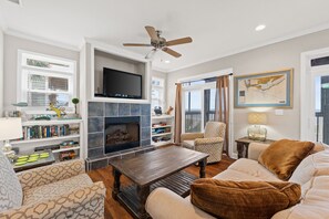 A living room with a fireplace, television, bookshelves, and a comfortable seating area.
