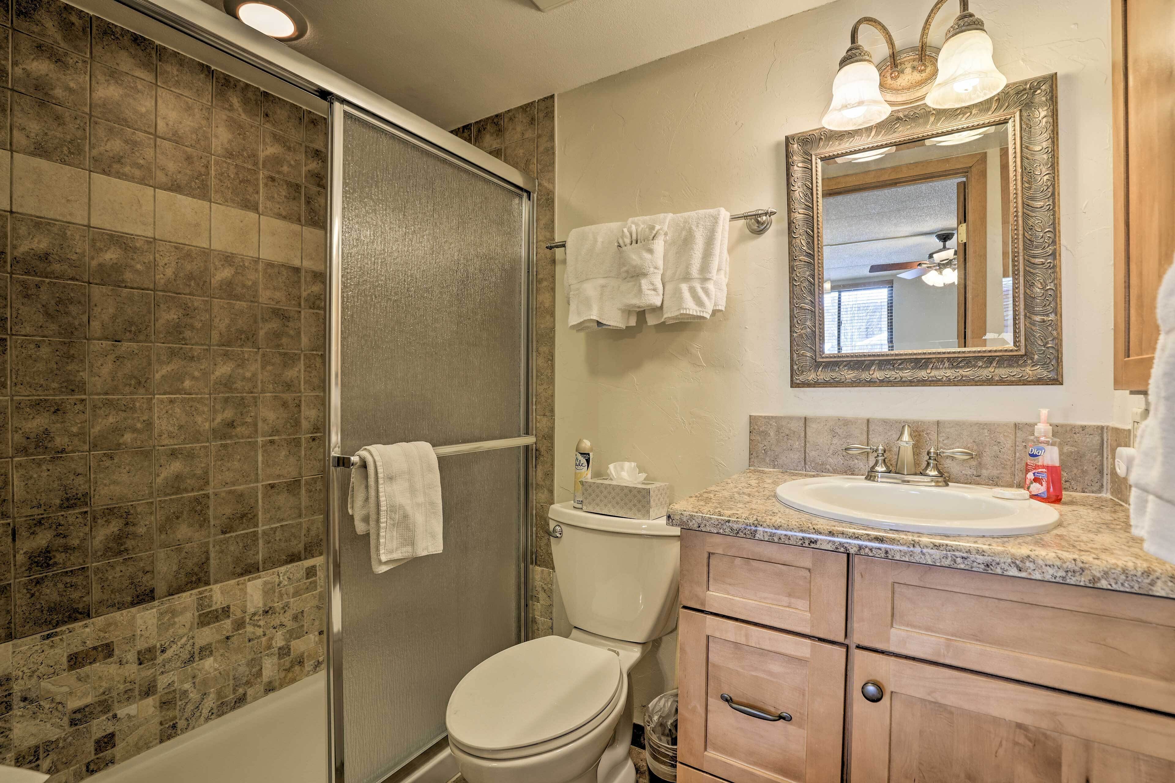 Een badkamer met douche, toilet, wastafel en opbergmeubel.