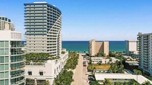 Un hôtel situé sur la côte, avec un bâtiment aux lignes courbes, une vue sur la plage et un espace piscine.