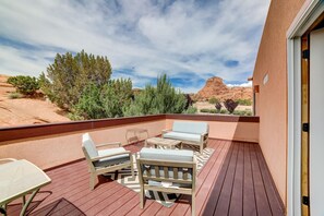 Eine Terrasse mit Gartenmöbeln und Blick auf eine Wüstenlandschaft.