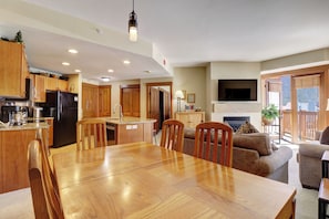 Cozy living area with a central dining table, kitchen, and comfortable seating area.