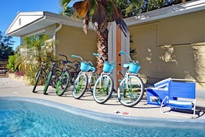 A poolside area with bicycles and a lounge chair.