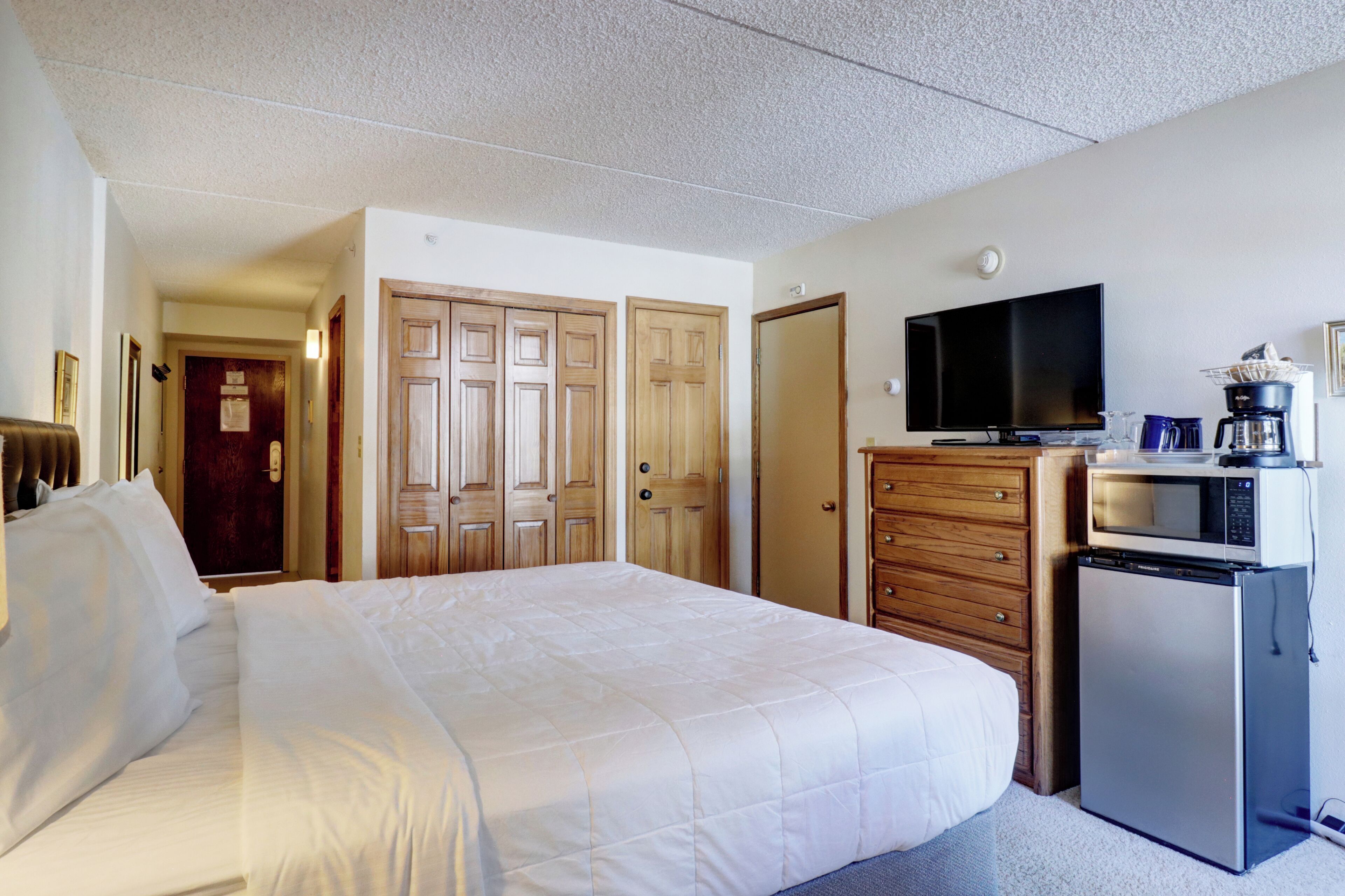 Une chambre d’hôtel équipée d’un lit, d’une télévision, d’un four à micro-ondes et d’un réfrigérateur.