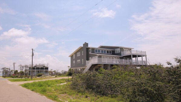 A two-story house with a balcony and a stop sign in the background. - 6 bdrm home W/Beach & Bay Access (Cape San Blas)