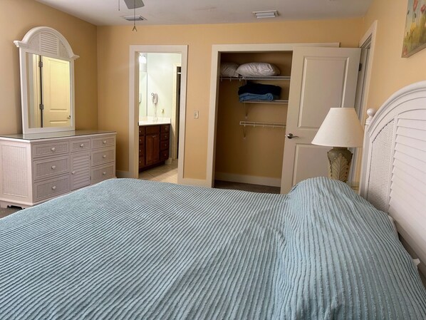 A bedroom with a bed, dresser, closet, and a mirror.