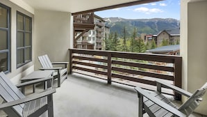 A balcony with a view of a mountain range, wooden railings, and two white chairs. - Amazing Center Village Unit, Extra Sleeping Area, Walk to American Eagle - PP3 (Copper Mountain)