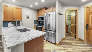 A modern kitchen with wooden cabinets, stainless steel appliances, and a marble countertop. - Amazing Center Village Unit, Extra Sleeping Area, Walk to American Eagle - PP3 (Copper Mountain)