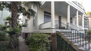 Ein zweistöckiges Haus mit einer Veranda, einer Treppe und einem Weg zum Eingang.