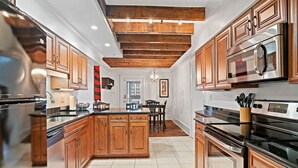 Une cuisine moderne avec des meubles en bois, des appareils électroménagers en acier inoxydable et un îlot central.