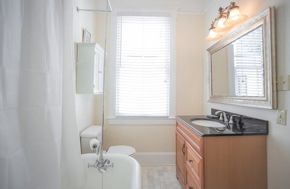 Un baño con bañera, inodoro, lavabo y tocador.