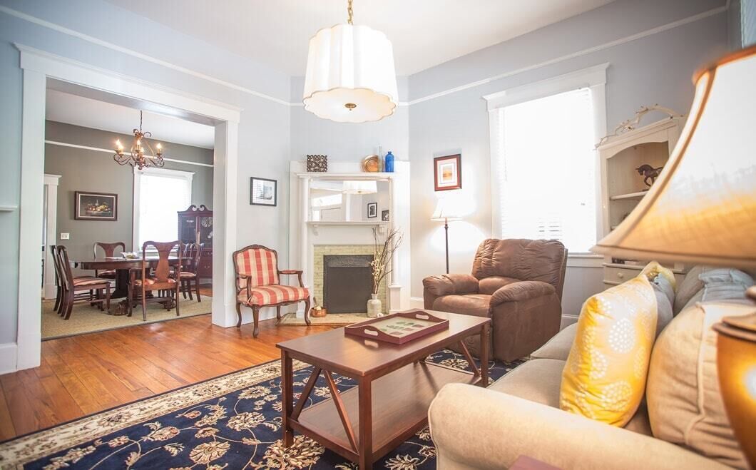A living room with a fireplace, a dining area, and a sofa.