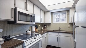 A modern kitchen with white cabinets, a microwave, stove, and refrigerator. - Pitchfork 456: Town of Jackson- Renovated- Walk to Town Square (Jackson)