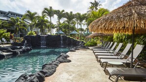 A resort pool with lounge chairs, a waterfall, and tropical vegetation. - Ocean and Mountain Views - Spacious Cliffs 5-301 .. 1 BR plus Loft (Princeville)