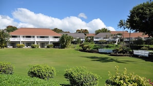 Ein Golfplatz mit einem Clubhaus, das mehrere Stockwerke und ein rotes Dach hat.