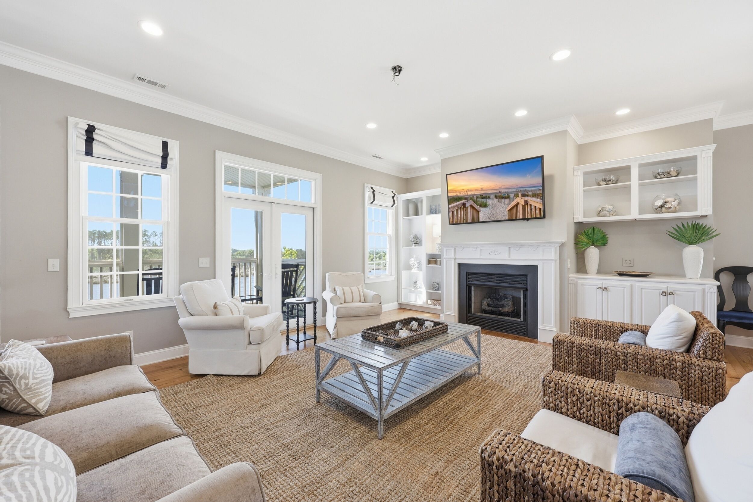 A spacious living room with a fireplace, a large window, and a view of the outdoors.