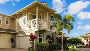 A two-story house with a balcony, garage, and well-maintained landscaping.