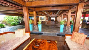 A spacious lobby with a wooden coffee table, cushioned seating, and potted plants. - Aloha Condos, Hanalei Bay Resort, Condo 6303, Ocean View, AC (Princeville)