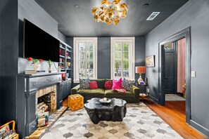 Un salon moderne avec une cheminée, un canapé, une table basse et une bibliothèque.
