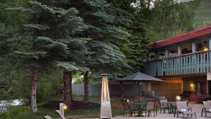 Ein Poolbereich mit Liegestühlen, einem Tisch und einem Gebäude mit Balkon.