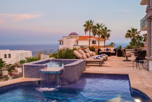 A luxurious outdoor pool area with a hot tub, lounge chairs, and a view of the ocean. - Oceanview Villa in Pedregal Best for Groups | Pool, Hot Tub, Gym & Cabo Views (Cabo San Lucas)