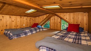 A wooden cabin room with two beds, a sloped ceiling, and skylights. - Family Cabin on 6 Acres w/ Lake Access & Hot Tub! (Springfield)