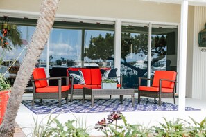 Relax in this inviting outdoor seating area with a central table and two chairs, surrounded by a beautiful view of the surrounding area and trees.